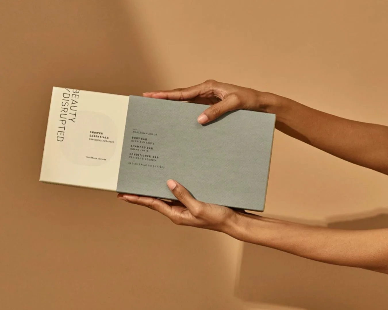 Hands holding Beauty Disrupted shower essentials box