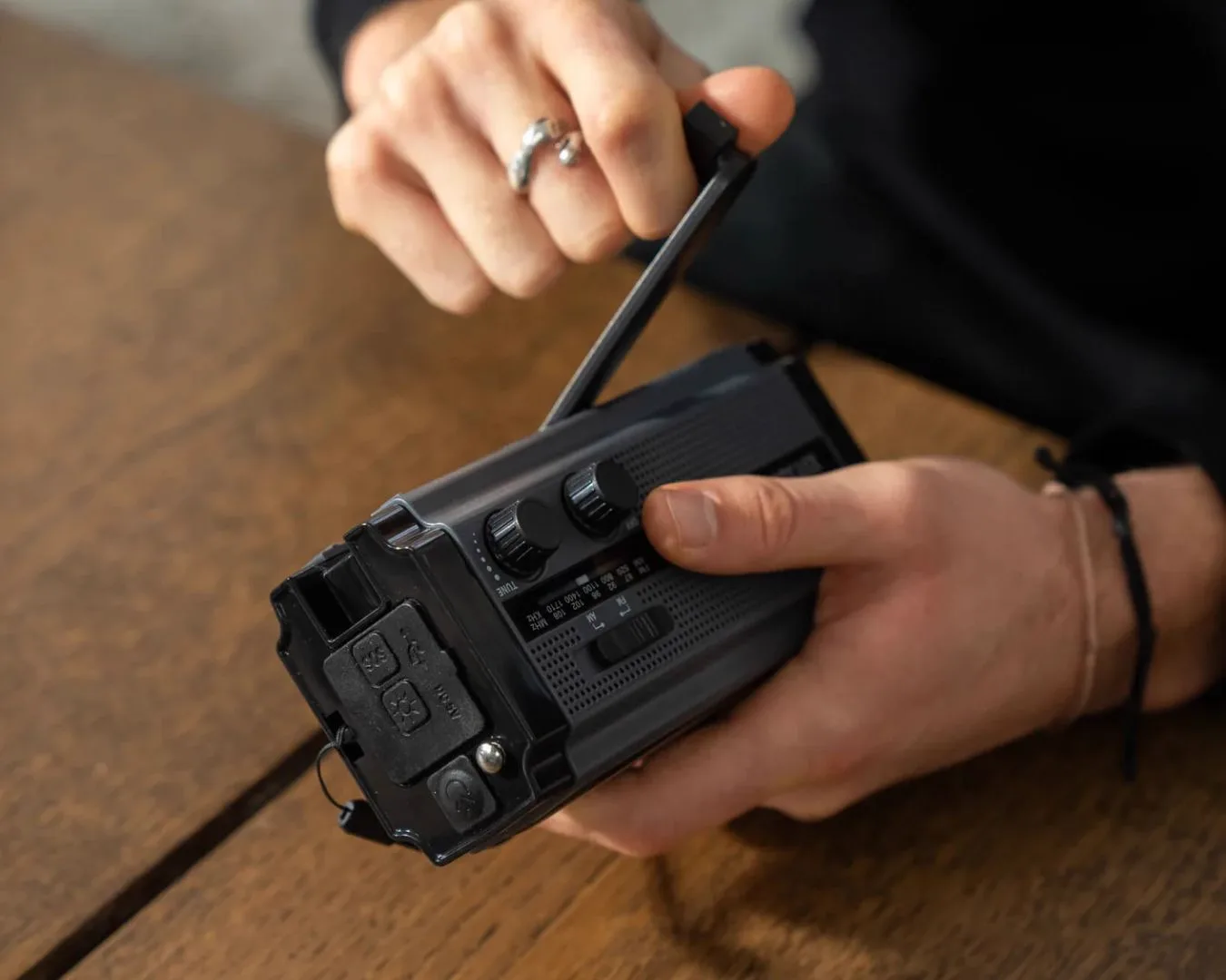 Hands holding emergency radio from Bered kit