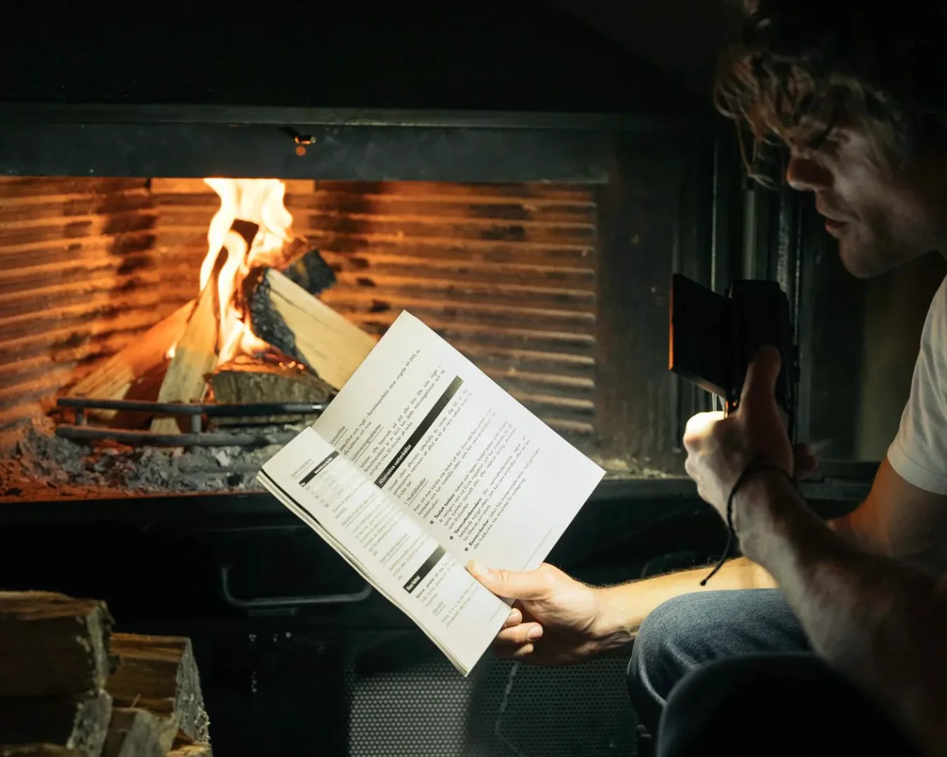Person reading Bered guide by fireplace