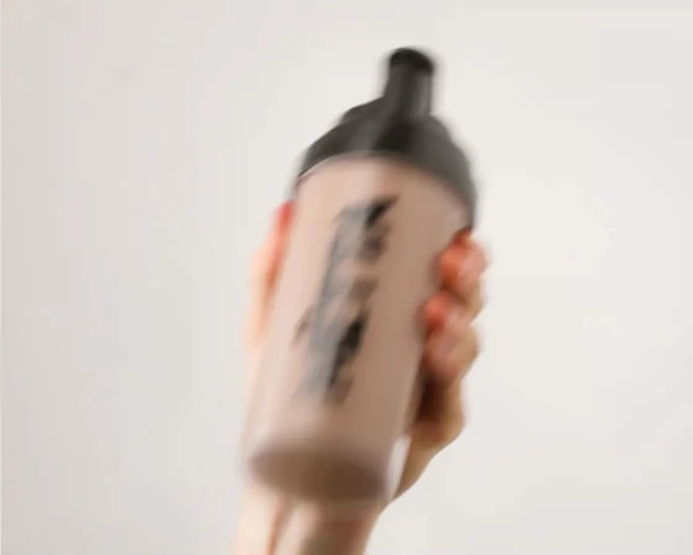 Hand holding Mëtta shaker bottle